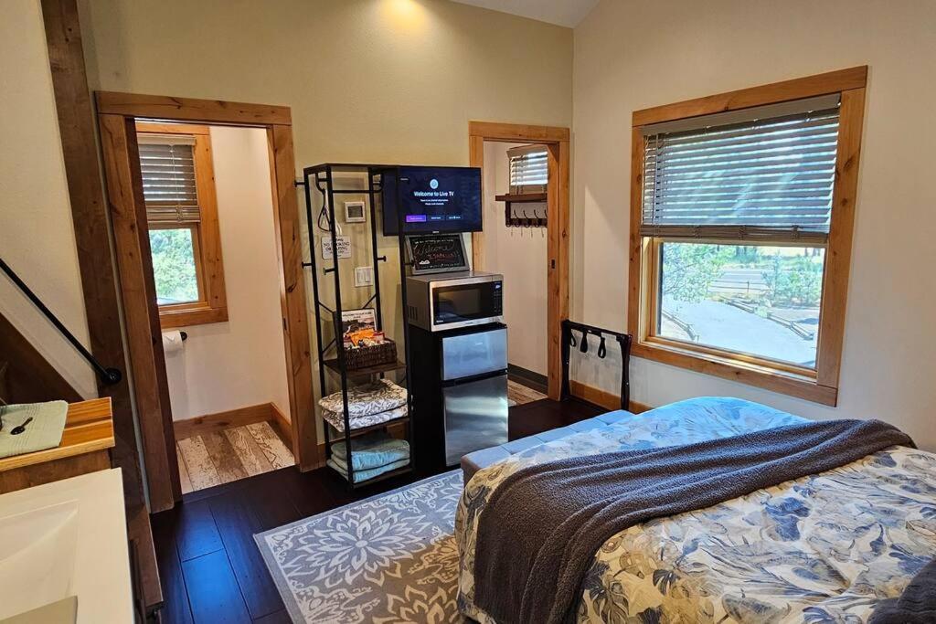 a room with a bedroom with a bed and a television at Beautiful Riverfront Near Mt Bachelor with Hot Tub in Bend