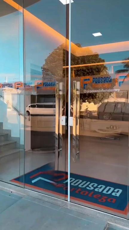 Un reflejo de un autobús en una pared de cristal. en Pousada Fortaleza, en Ribeira do Pombal