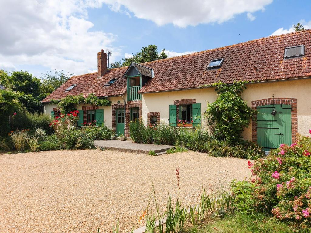 una casa con una porta verde e un cortile di Escapade en longère avec jardin au bord de l'Ozanne, Dangeau, 6 pers. - FR-1-581-25 a Dangeau