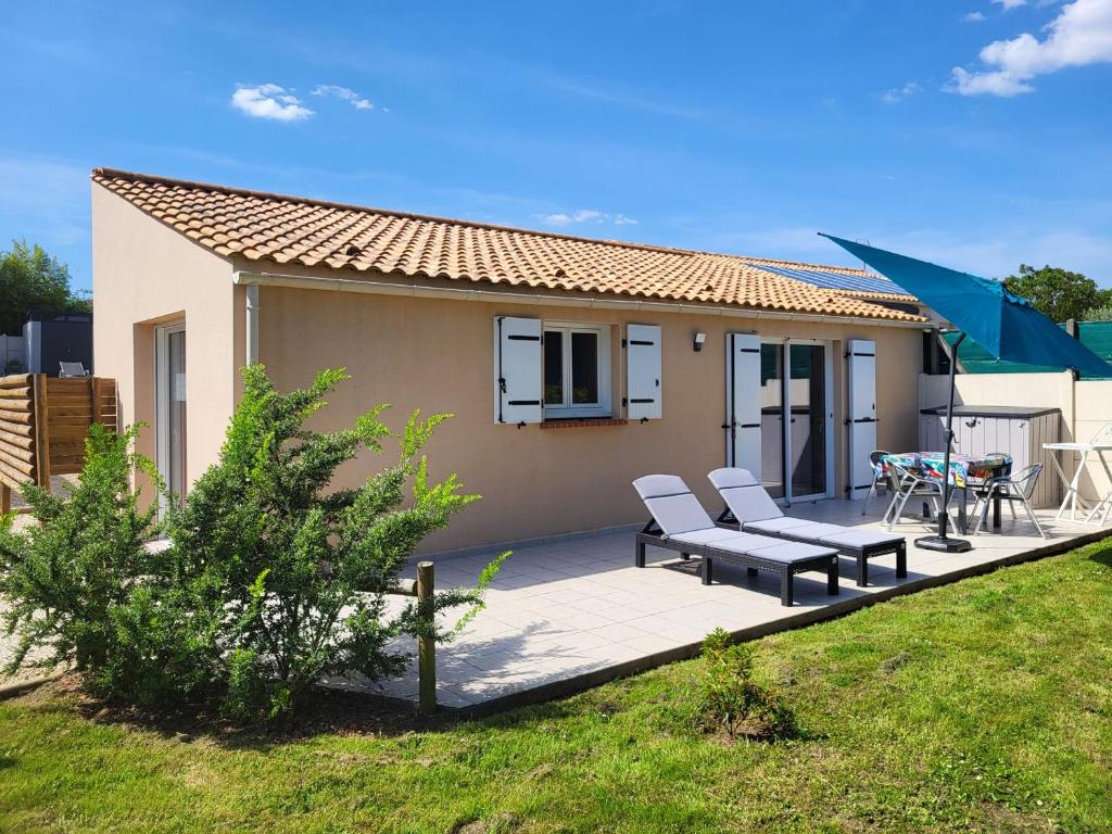 a house with two chairs and a table on a deck at Maison rénovée avec jardin partagé de 2000m² à 1,3 km de la plage Clemenceau, idéale pour 4 personnes - FR-1-426-510 in Saint-Vincent-sur-Jard