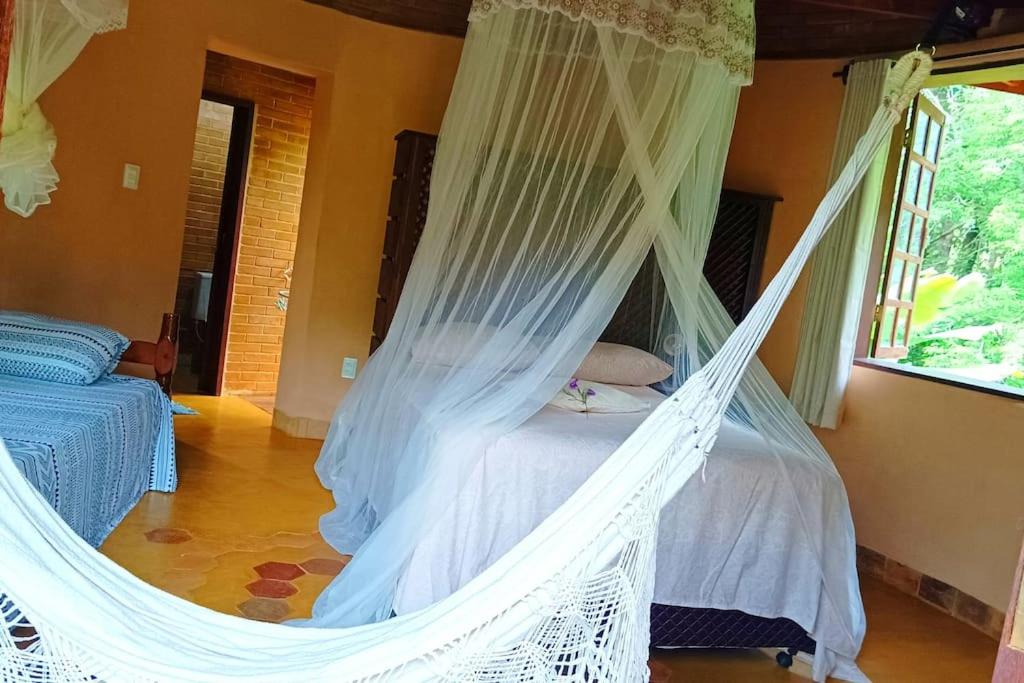 a white hammock bed in a room with a window at Casa Sustentável de Terra! in Lençóis