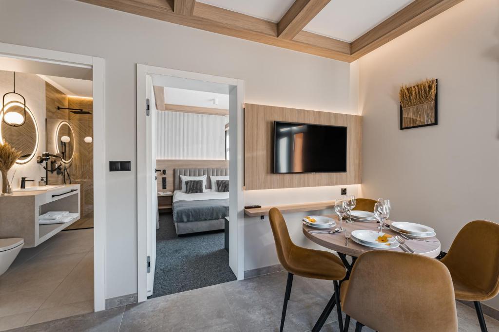 a dining room and living room with a table and chairs at Sosenka Pienińska in Szczawnica