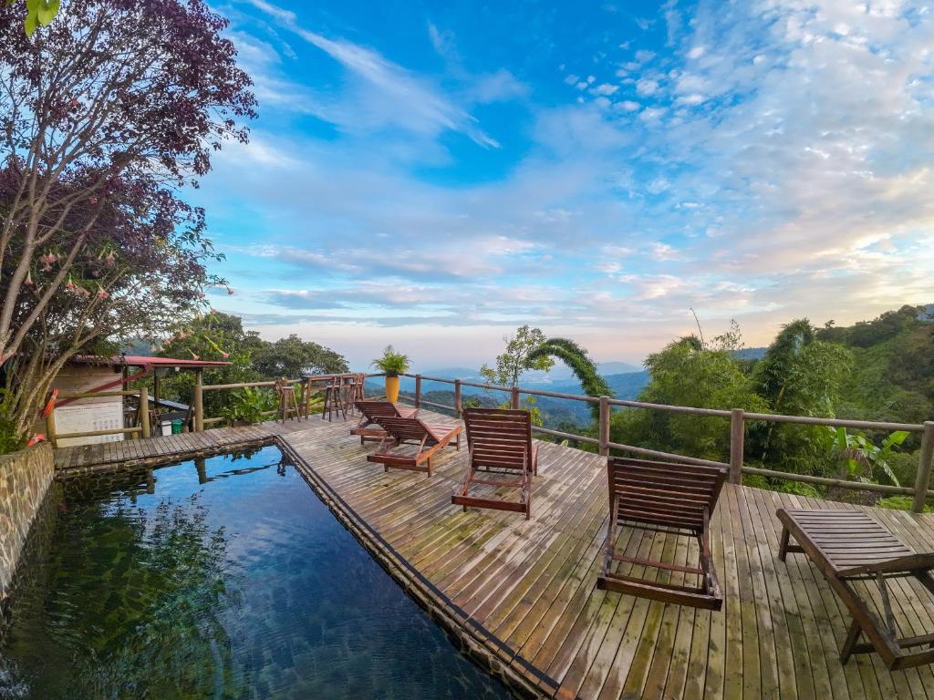 a deck with chairs and a swimming pool at Loma Nevada Minca Hotel in Minca