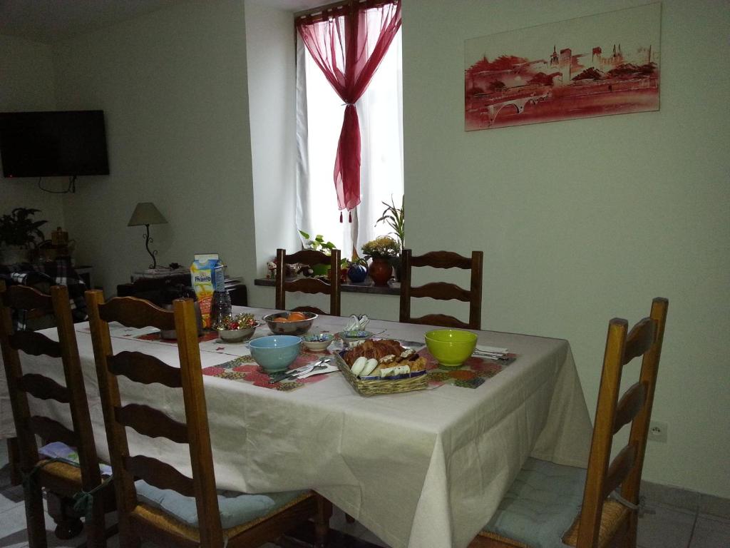 Conilhac-CorbièresにあるMillot Conilhacのダイニングルームテーブル(白いテーブルクロスと食べ物付)