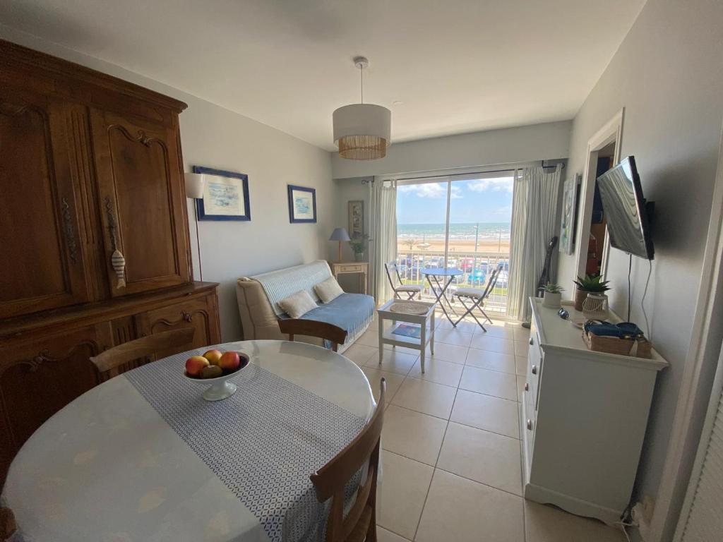 un salon avec une table avec un bol de fruits dessus dans l'établissement Appartement cosy face mer, avec terrasse et parking - Saint-Jean-de-Monts, secteur Casino - FR-1-323-550, à Saint-Jean-de-Monts