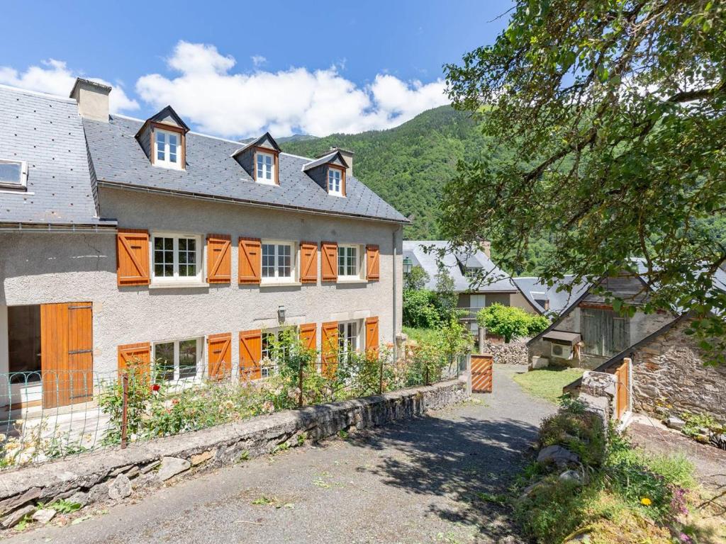 a large house with orange doors and a yard at Maison typique 10 pers. avec Wifi, jardin et terrasse, à 5 min de Loudenvielle - FR-1-695-58 in Avajan
