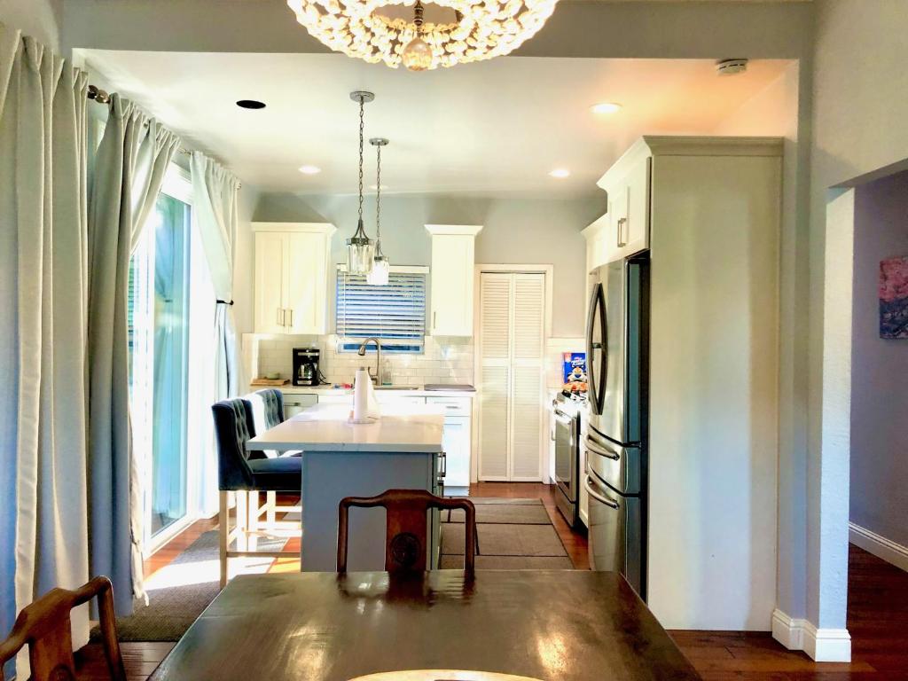 a kitchen with white cabinets and a table in it at Oasis Point in Richmond