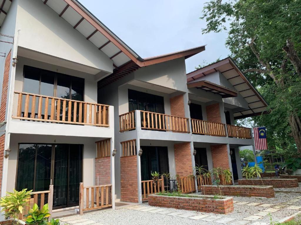 ein Haus mit Balkon an der Seite in der Unterkunft Red Coral Cottage in Tanjung Rhu