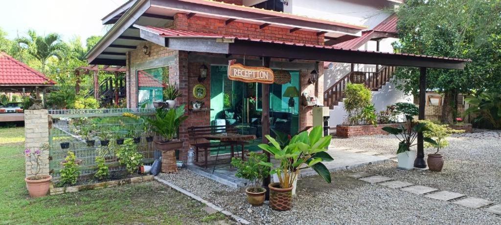 ein kleines Gebäude mit Pflanzen davor in der Unterkunft Red Coral Cottage in Tanjung Rhu