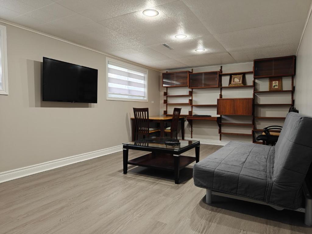 a living room with a couch and a table at Pool House in St. Catharines