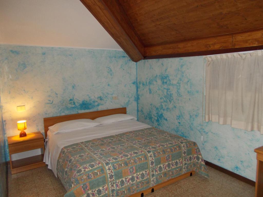 a bedroom with a bed and a blue wall at Albergo Stazione in Brescia