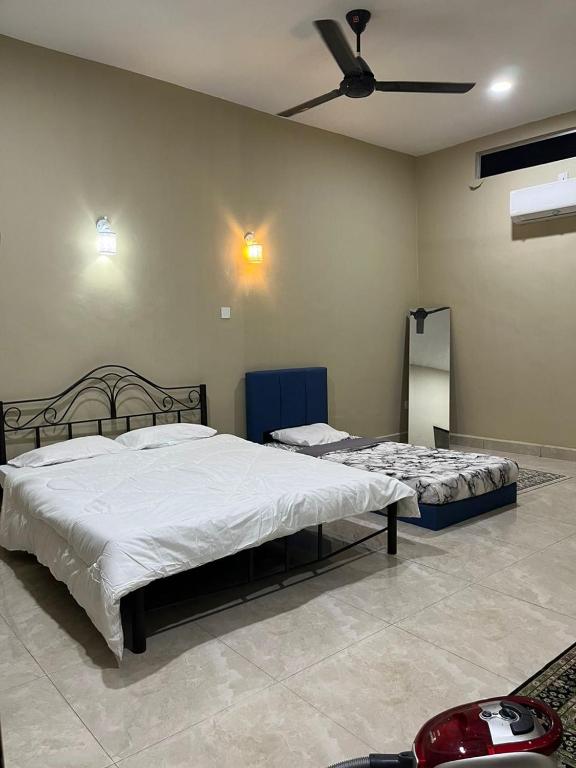 a bedroom with two beds and a ceiling fan at Al-Hijrah Homestay Meru Klang in Kapar