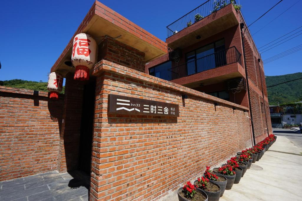 新营三时三舍精品民宿慕田峪长城店的砖砌的建筑,旁边标有标志