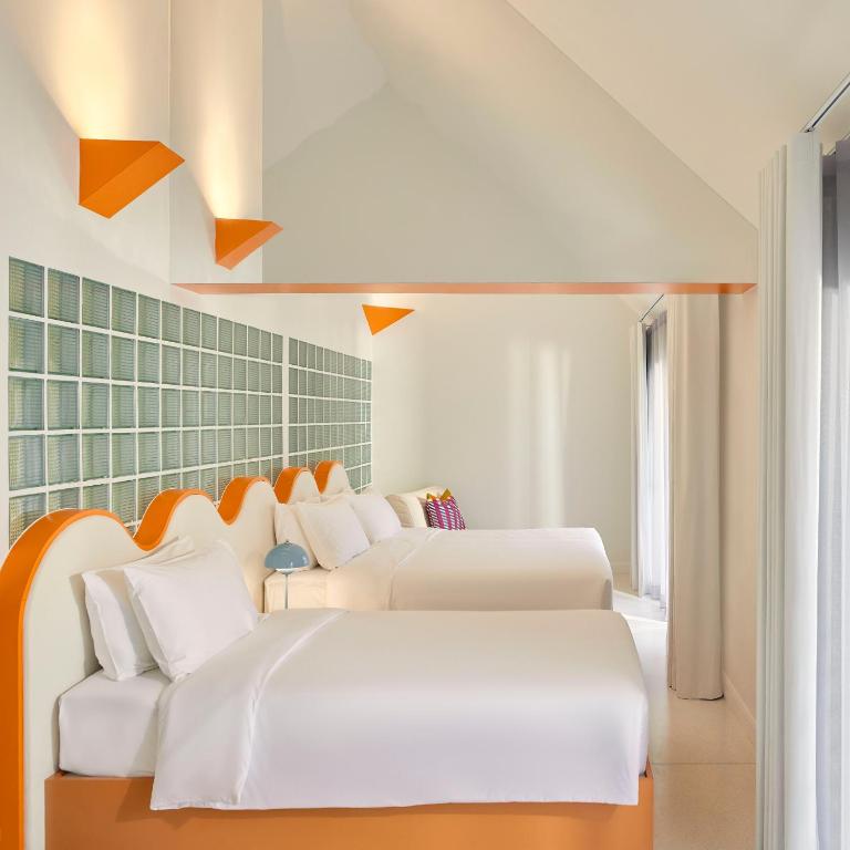 two beds in a room with orange and white at Molly Beach House by Yudee Assets in Hua Hin
