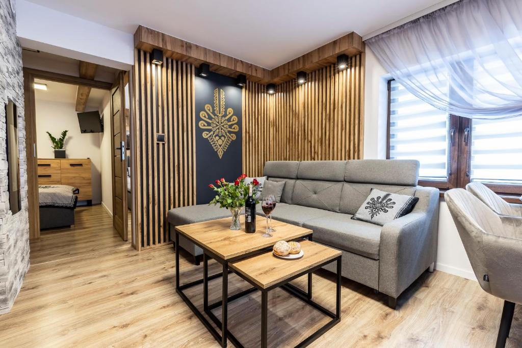 a living room with a couch and a table at Apartament TatraVika in Kościelisko