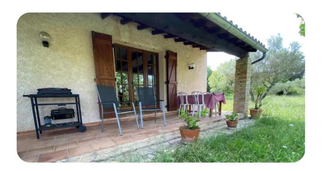 une véranda couverte d'une maison avec un grill dans l'établissement L'oliveraie, à Correns