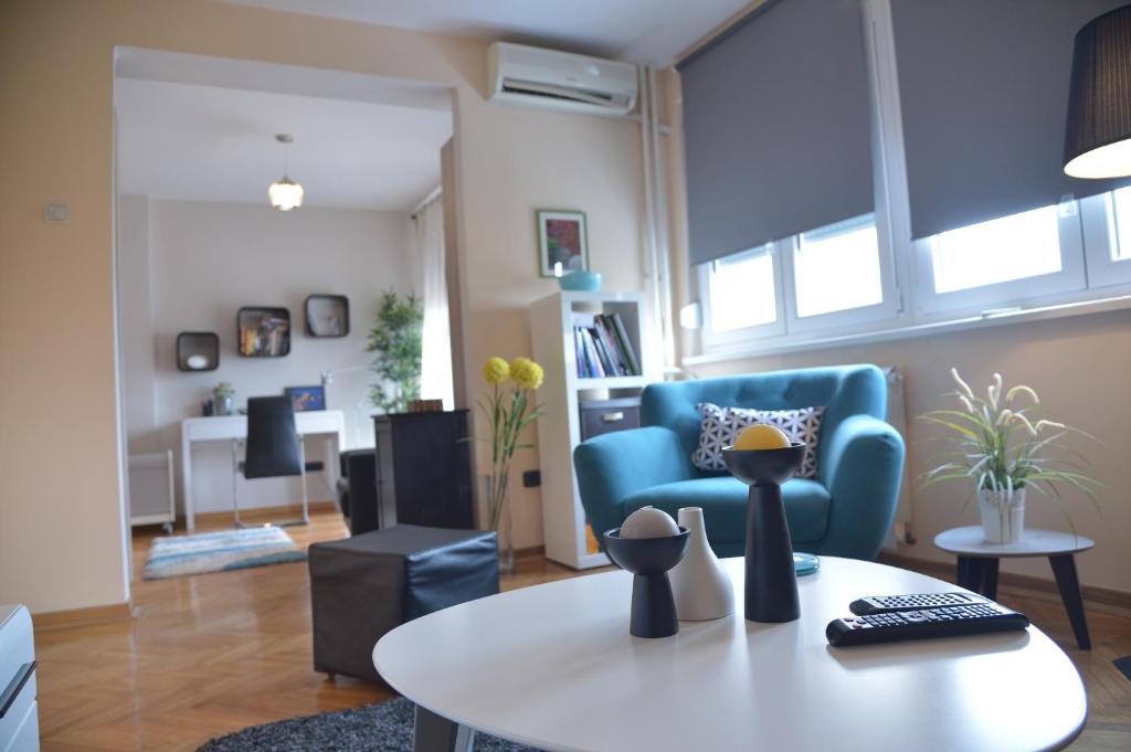 un soggiorno con divano blu e tavolo di Apartment Danica a Belgrado