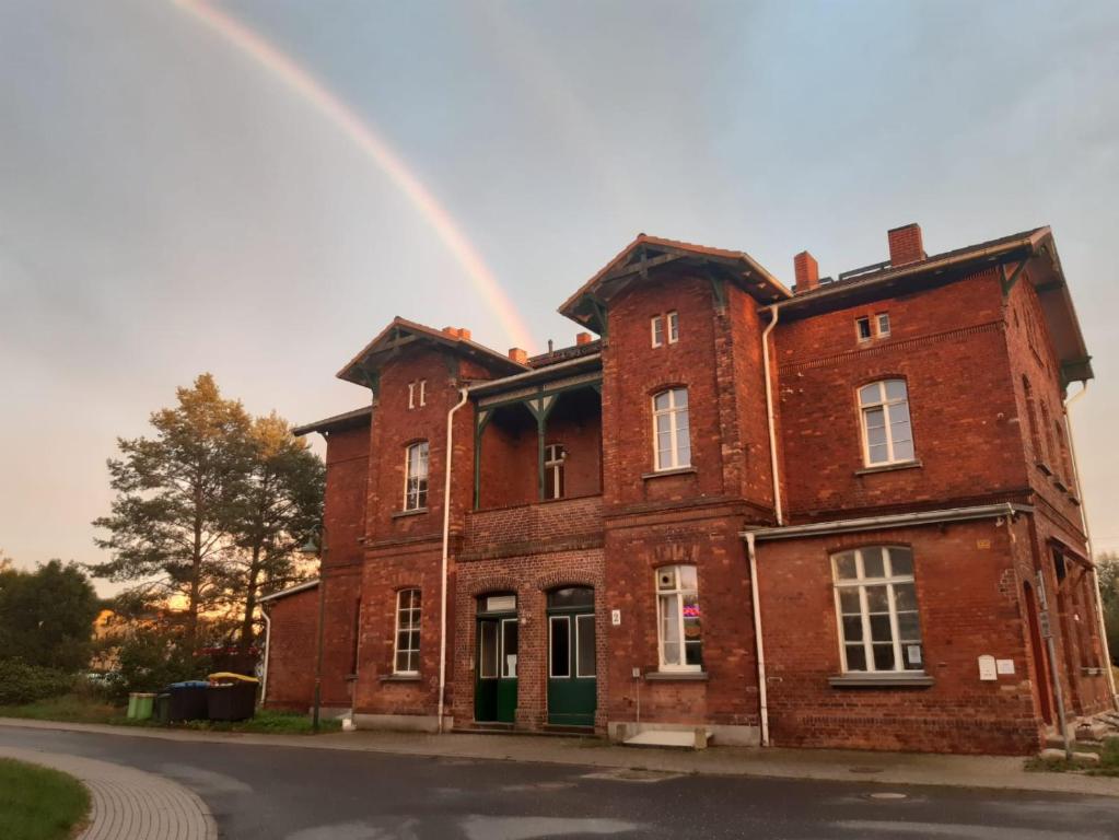a rainbow over an old brick building with at Privatzimmer ohne Komfort im historischen Bahnhof Lalendorf in Lalendorf