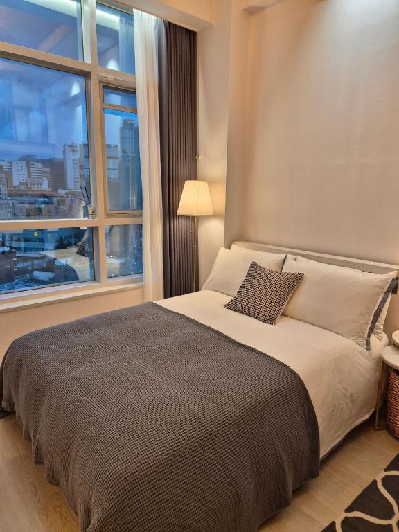 a bedroom with a large bed with a large window at Sunny House in Seoul