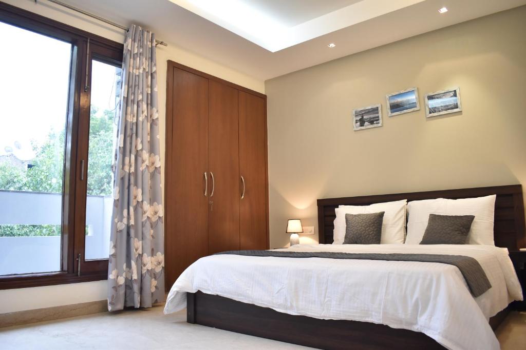 a bedroom with a bed and a large window at Two Green Park in New Delhi