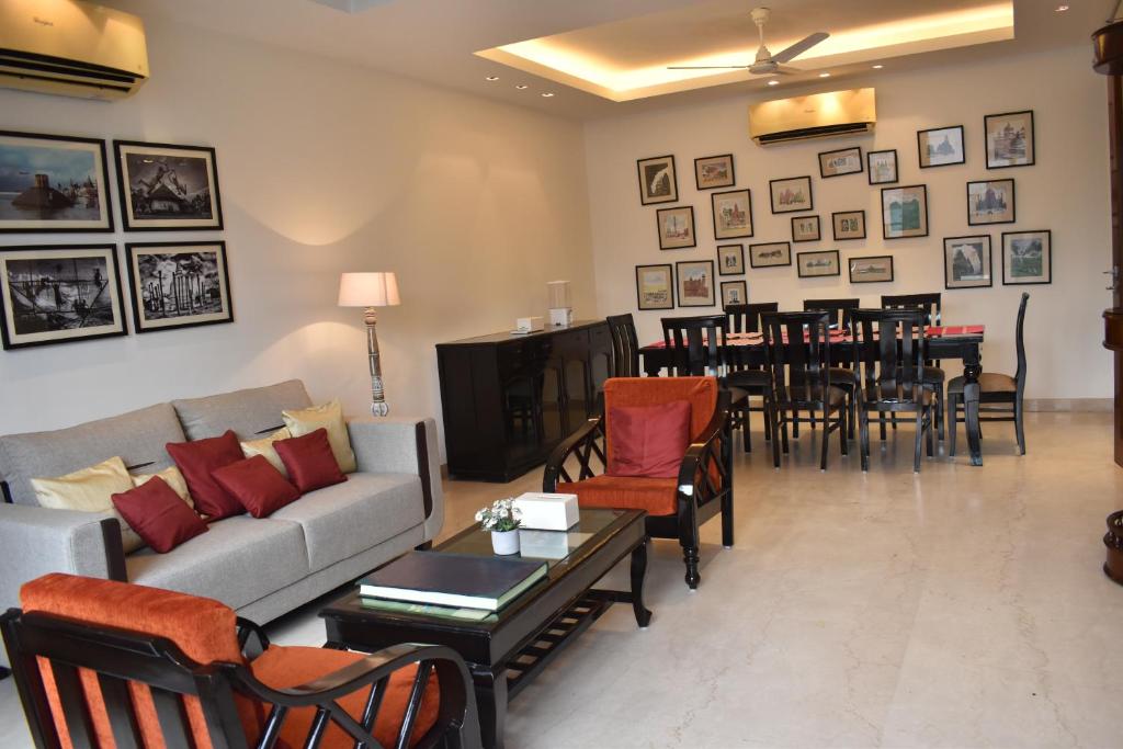 a living room with a couch and a table and chairs at Two Green Park in New Delhi