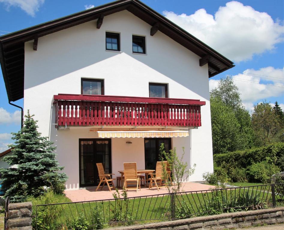 a white house with a red balcony at Villa Hilde in Oy-Mittelberg