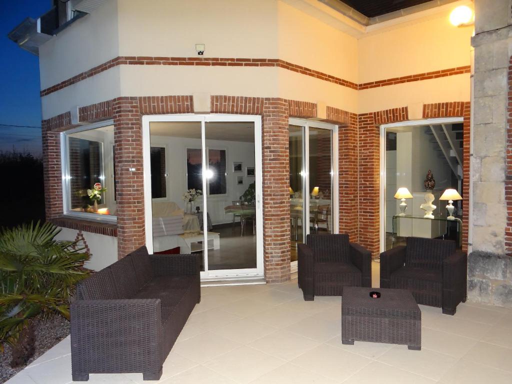 une maison avec deux canapés et une terrasse dans l'établissement gite la fécampoise près de Fécamp, à Ganzeville