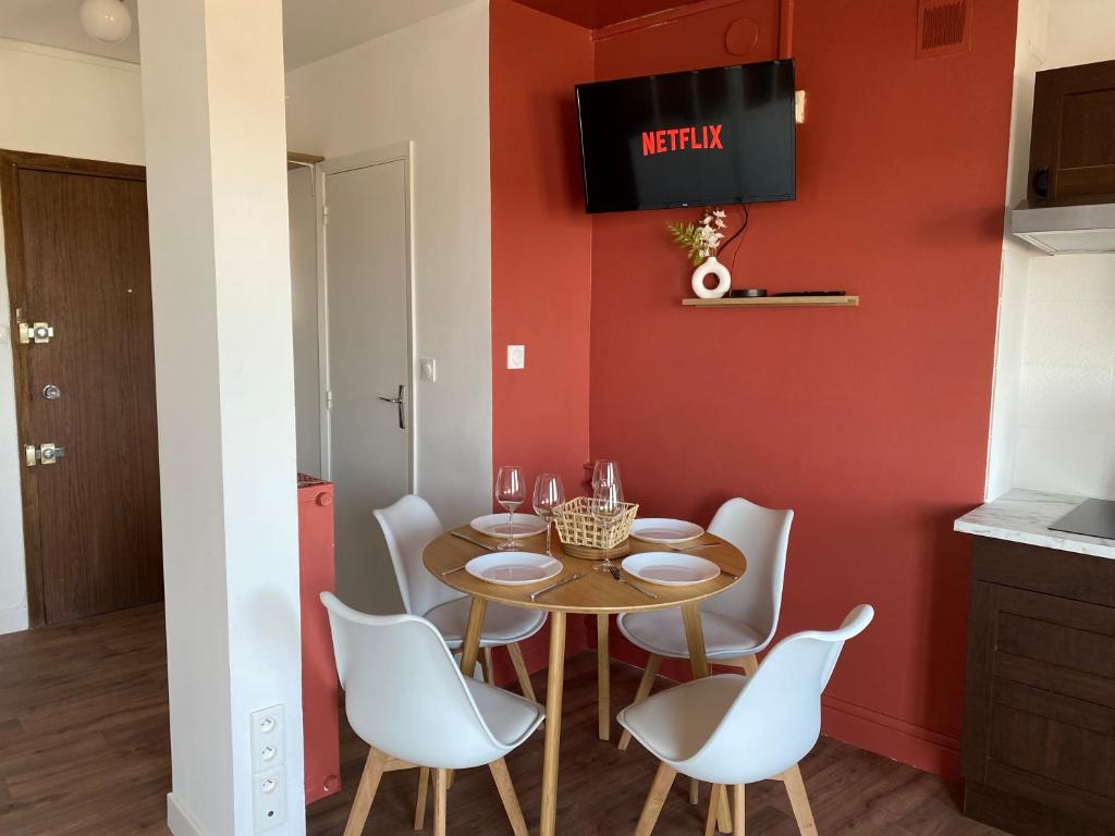 une salle à manger avec une table et des chaises blanches dans l'établissement Appartement Pont Montaudran, à Toulouse