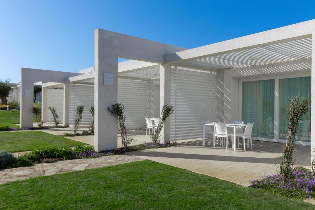 スティンティーノにあるStunning Capo Falcone Charming Apartments for 4 people B4P Bilo4 Premiumのテーブルと椅子のあるパティオのある家