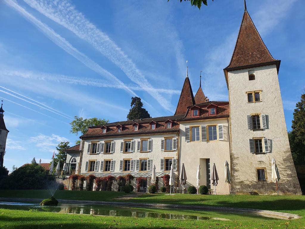 a large building with a tower on top of it at Schloss Münchenwiler in Murten