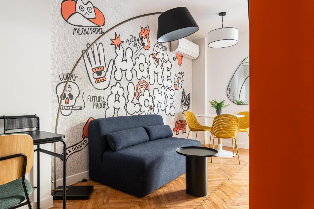 a living room with a couch and a wall with graffiti at MIXT by Zoia Living in Athens