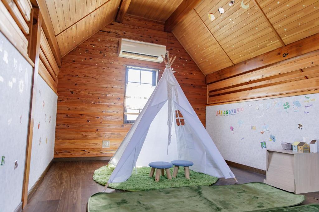 a room with two stools and a teepee at ocean resort mint オーシャンビューを満喫!かわいい三角屋根の三階建て貸切別荘 南房総白浜 in Shioura