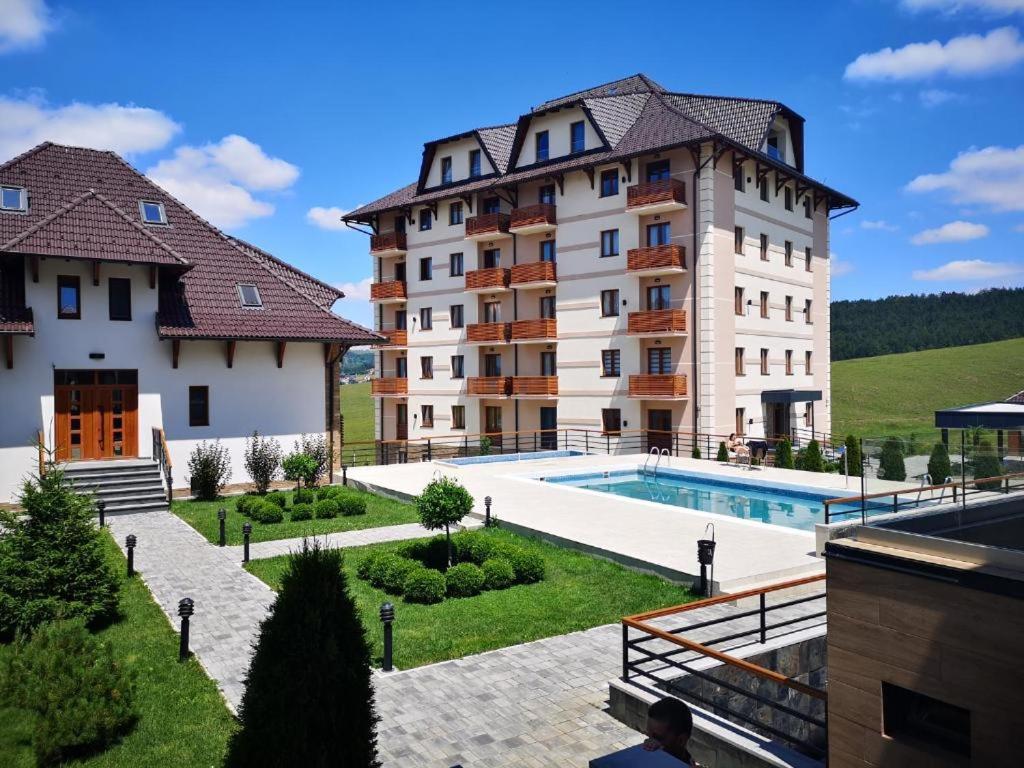 a large building with a swimming pool in front of it at Zlatibor Hills, Top 41 in Zlatibor