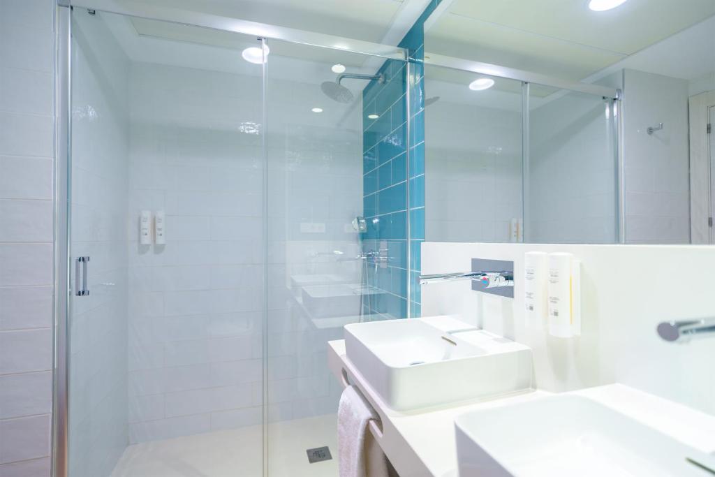 a bathroom with a glass shower and a sink at Spirit Hotel Benalmadena Beach in Benalmádena