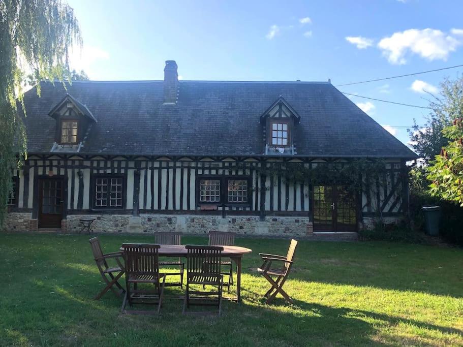 une table et des chaises devant une maison dans l'établissement Charmante Longère Piscine chauffée 8x4 Terrasse, Mer & Campagne Normandie, à Saint-Étienne-la-Thillaye