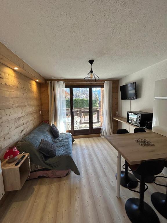une chambre avec un lit, un bureau et une table dans l'établissement Chaleureux appartement moderne, à Briançon