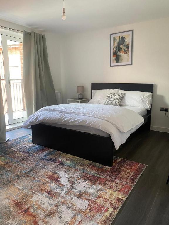 a bedroom with a large bed and a rug at Cozy City Apartment in Rainham in Rainham