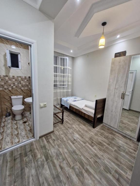 a bathroom with a bed and a toilet in a room at Green paradise in Batumi