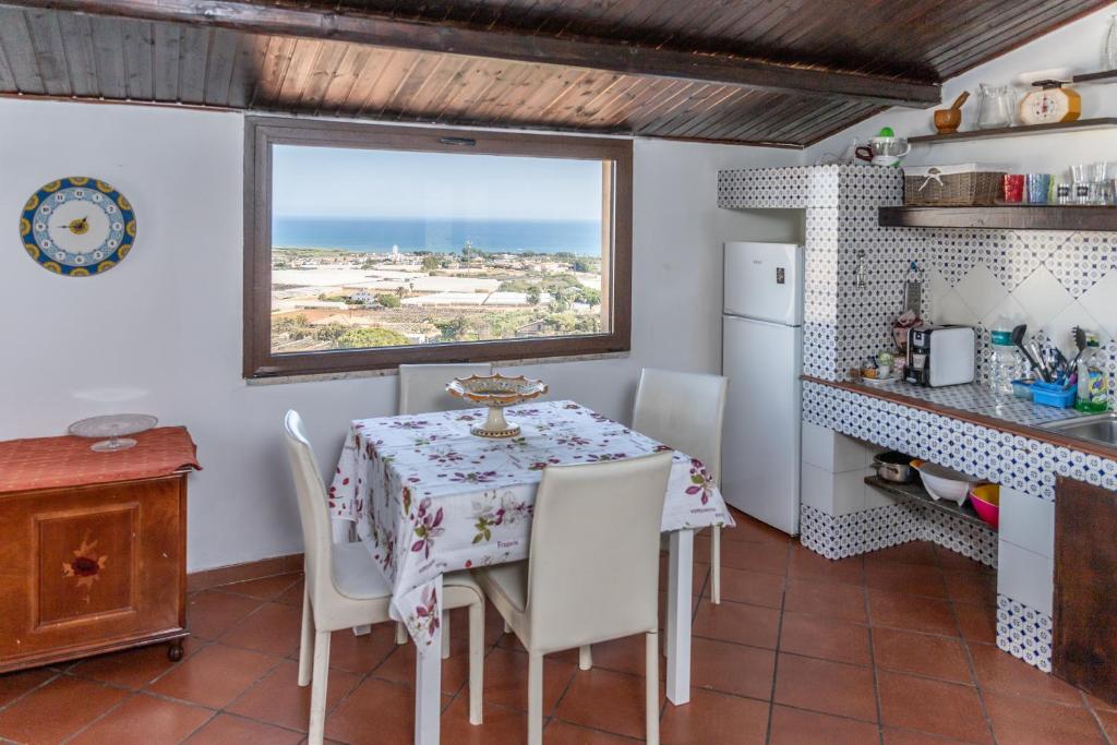 a kitchen with a table and chairs and a window at Casa Andrea in Marina di Ragusa