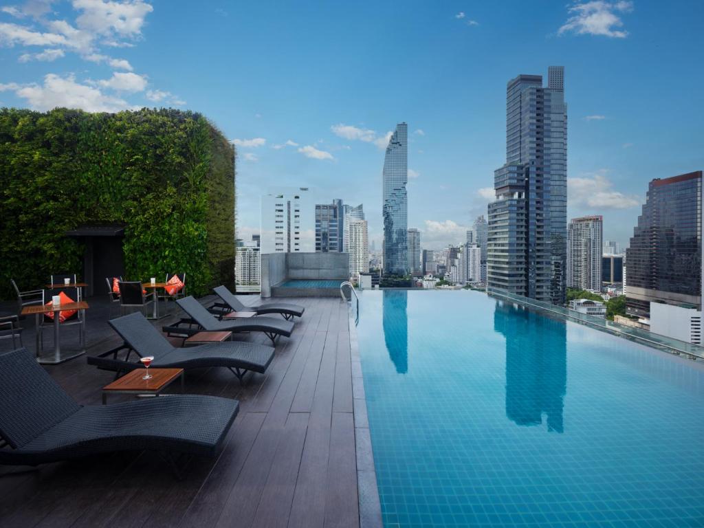 una piscina con tumbonas y vistas al perfil urbano en Amara Bangkok Hotel, en Bangkok