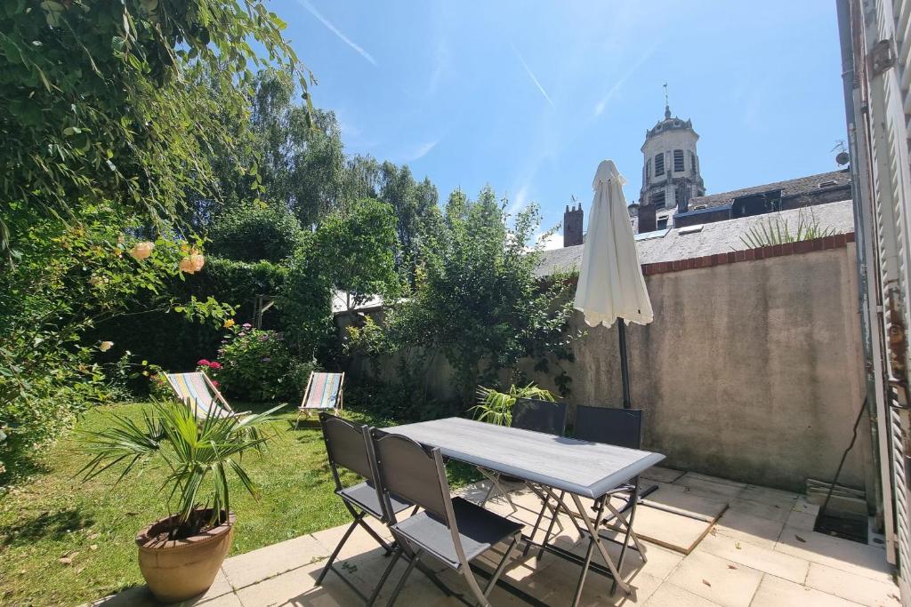 un patio avec une table, des chaises et un parasol dans l'établissement 