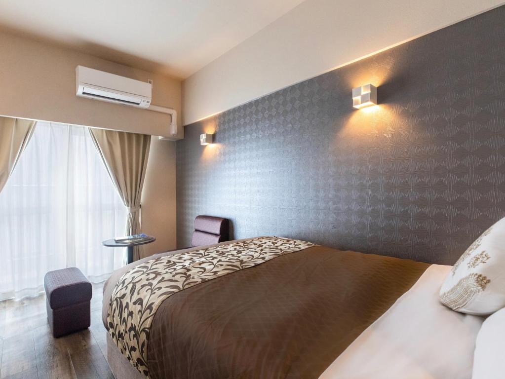 Postel nebo postele na pokoji v ubytování CONDOMINIUM HOTEL Riyuka in KADENA 1