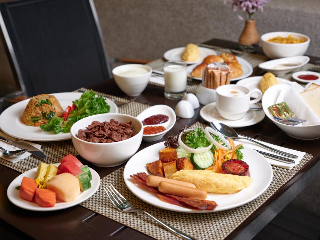 A close view of a full cooked breakfast with fruit, pastries and drinks.