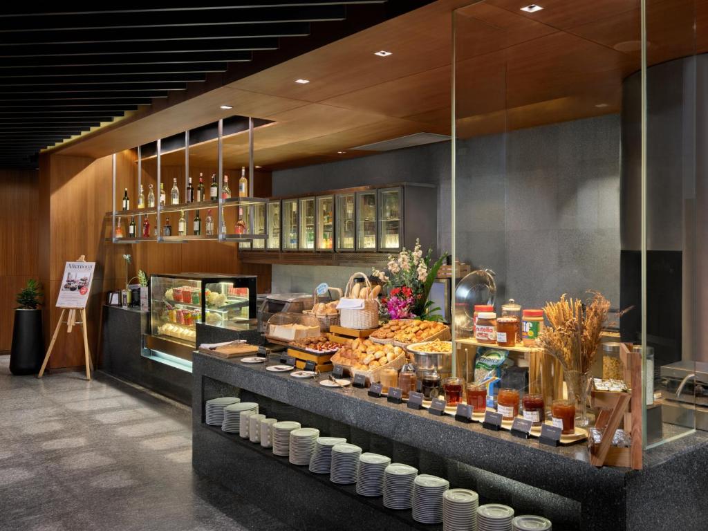A bakery and beverage display with pastries, preserves and chilled drinks.