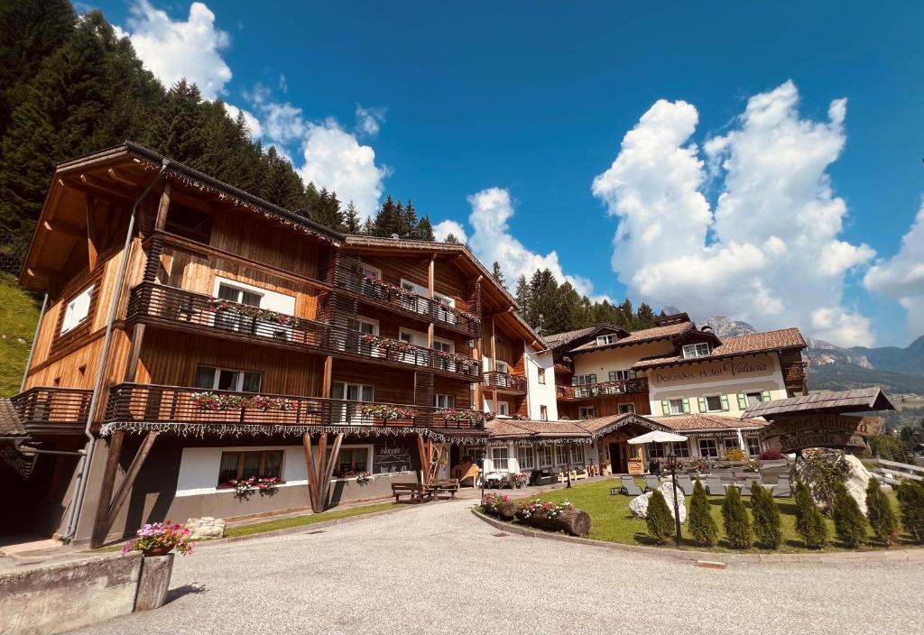 a large building with balconies on a mountain at Hotel Valacia in Pozza di Fassa