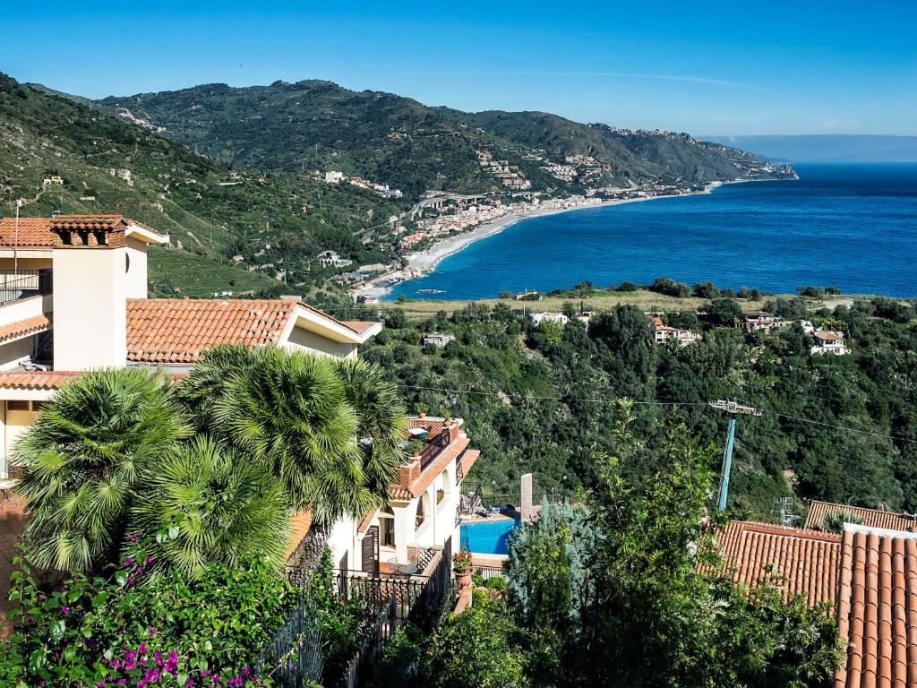 een uitzicht op de oceaan en een resort bij Hotel Sirius in Taormina