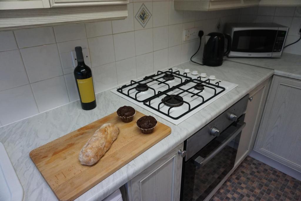 eine Küchentheke mit Herd, Schneidebrett und einer Flasche Wein in der Unterkunft Landau House in Bristol