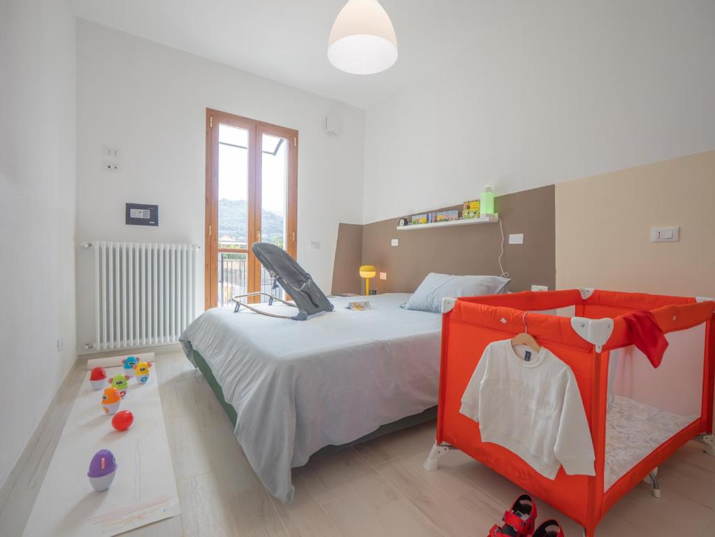 una camera con letto, culla e tavolo di Babyaccommodation Family Garden II a Pietra Ligure