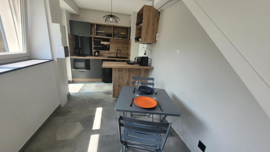 a small kitchen with an orange plate on a table at Au pied de la Basilique de Saint Nicolas de port in Saint-Nicolas-de-Port