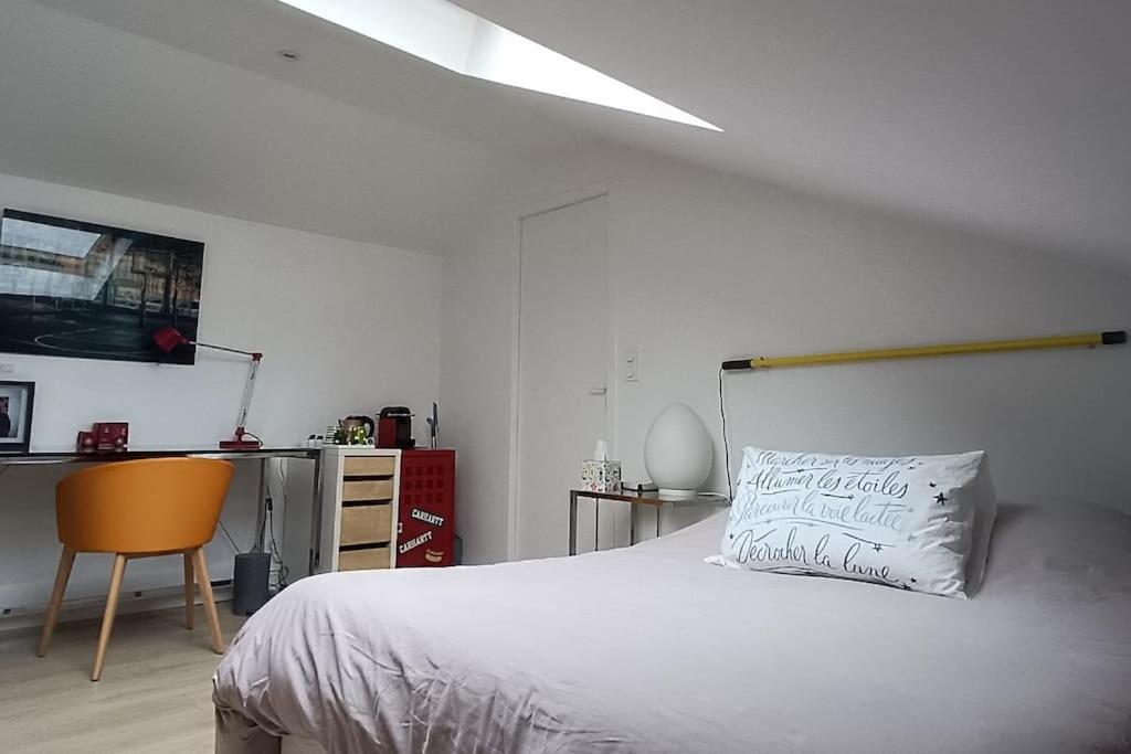 une chambre avec un lit avec un oreiller dessus dans l'établissement Le regard bleu, à Rennes